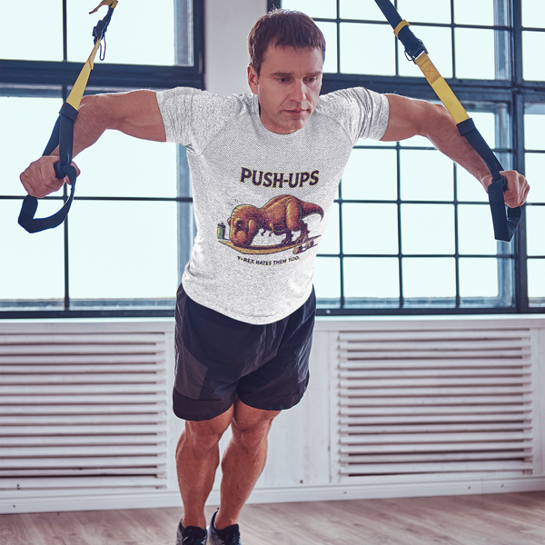 T-Rex Push-Up T-Shirt – Funny Dinosaur Workout Graphic Tee featuring a comical t rex hates push ups design, shown during a TRX workout for fitness lovers.