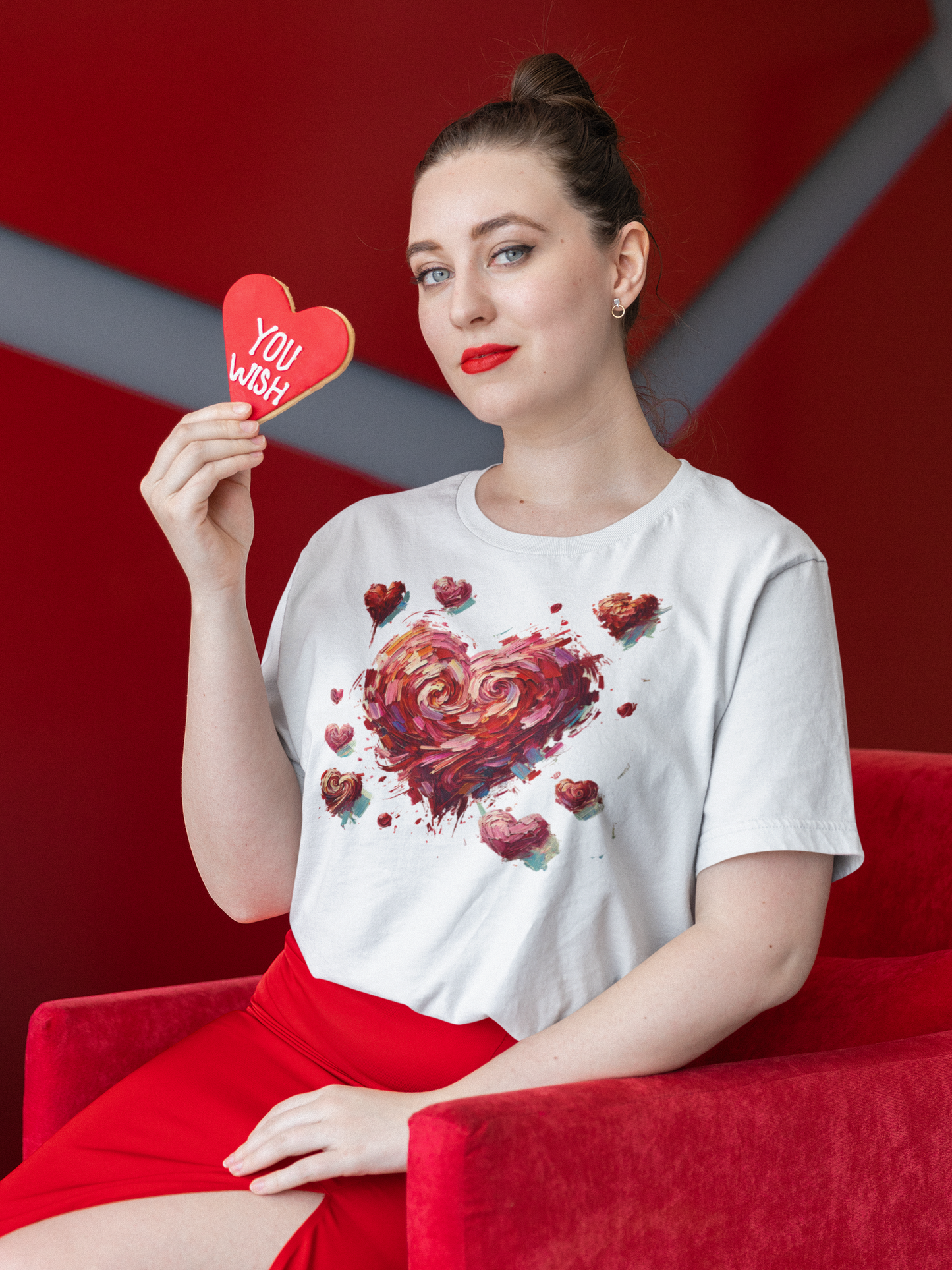 Woman in red chair holding cookie wears White Impressionistic Heart T-Shirt – Artistic Valentine's Day Tee