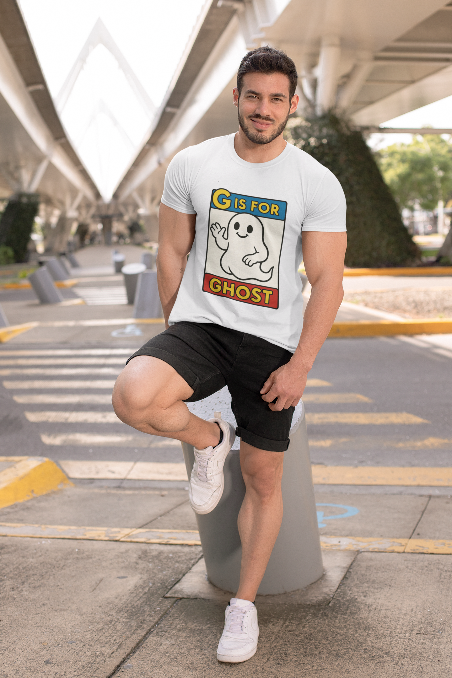 G is for Ghost T-Shirt – Funny Monster Alphabet Halloween Tee in white, modeled casually with shorts, funny Halloween ghost shirt with cartoon ghost graphic.