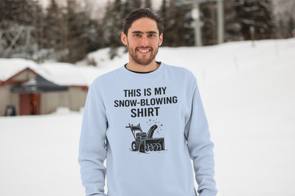 This Is My Snow-Blowing Shirt – Funny Winter Chore Sweatshirt shown outdoors in snow, featuring a light blue tone and a humorous take on snow blowing during winter storms.