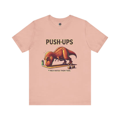 T-Rex Push-Up T-Shirt – Funny Dinosaur Workout Graphic Tee in peach with a humorous t rex push ups theme for active dinosaur lovers.