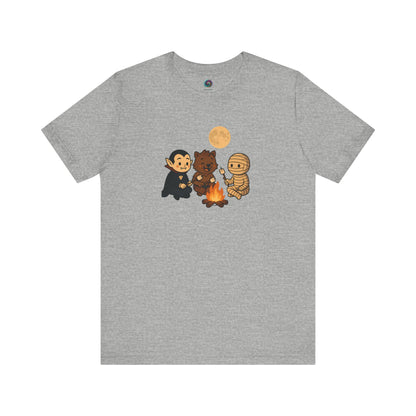 Halloween Monsters Campfire T-Shirt in athletic heather by WhimSpin, showcasing a whimsical monster trio sharing a sweet treat over a fire.
