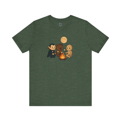 Halloween Monsters Campfire T-Shirt in Heather Forest Green with an adorable illustration of monsters bonding over marshmallows under a full moon.
