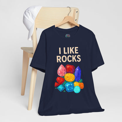 Navy blue I Like Rocks shirt from Whimspin with "I like rocks" text and colorful gemstone graphics on a white background. 