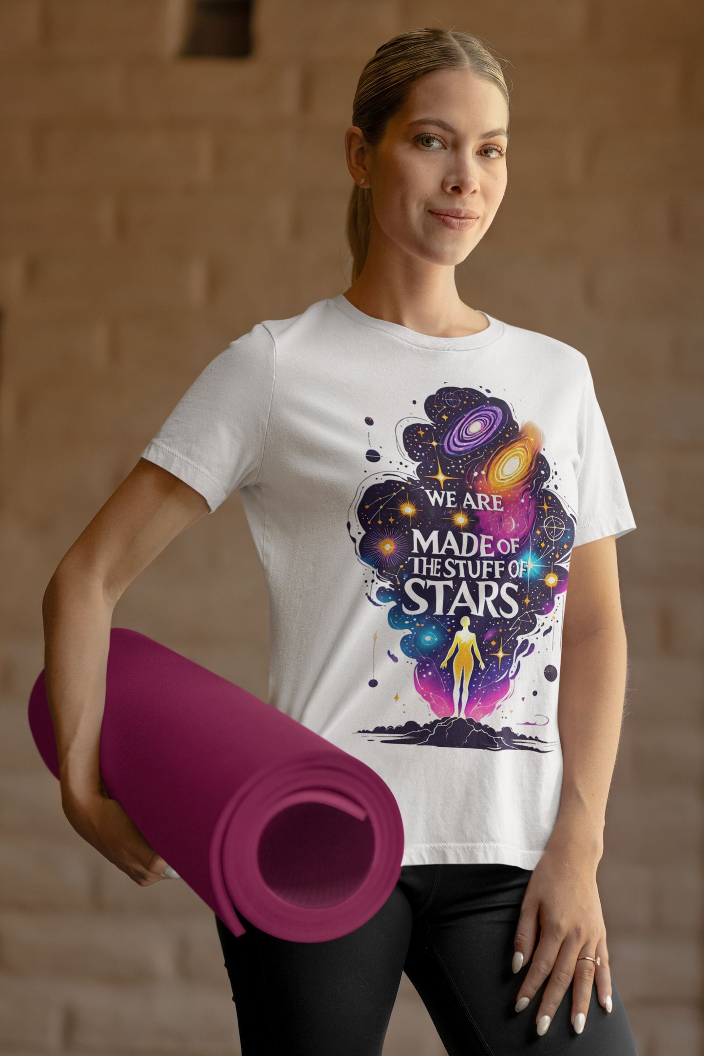 Woman holding a rolled up yoga mat wears a white carl sagan tee shirt with a graphic of a person's silhouette outlined by the expanse of the universe opening before her with swirls of galaxies and stars in the sky. Stuff of Stars Tee | Inspired by Carl Sagan Tee Shirt - WhimSpin - https://whimspin.com